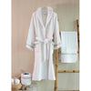 White Robe with Taupe embroidered trim hung up next to bamboo ladder with towel