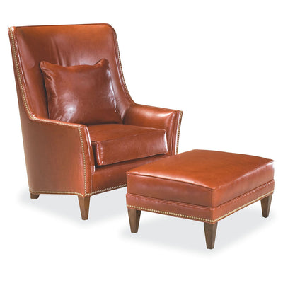 Brown leather chair with brass nailhead trim.