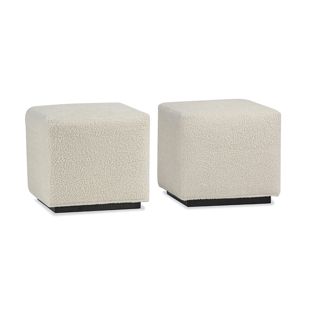 two cube benches in light colored fabric with dark base. 