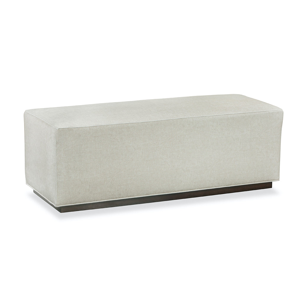 white rectangular bench covered in light colored fabric. 